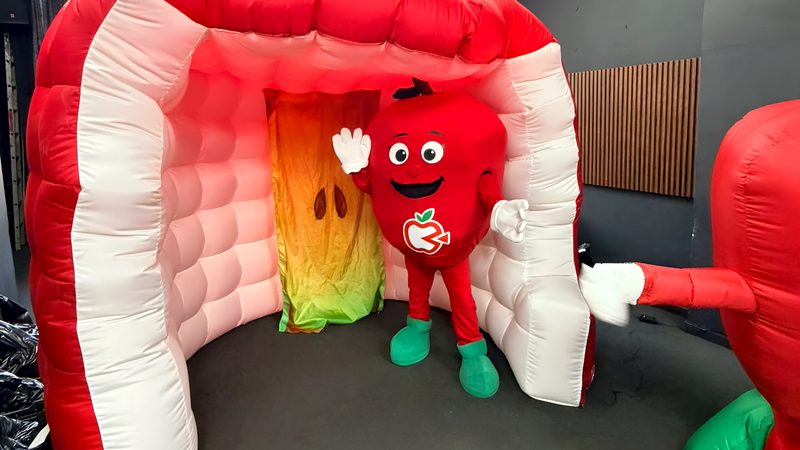 Cabina inflable roja con una botarga en la entrada