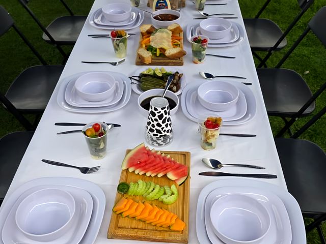 Mesa larga montada con platos y tablas de fruta