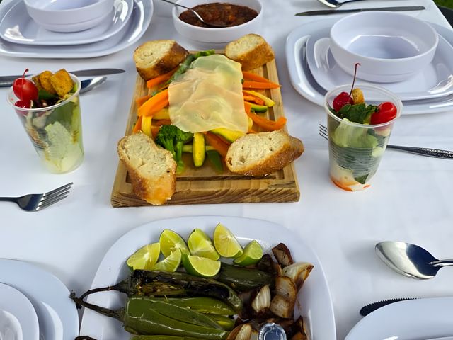 Mesa montada con tabla de quesos, verduras y chiles toreados